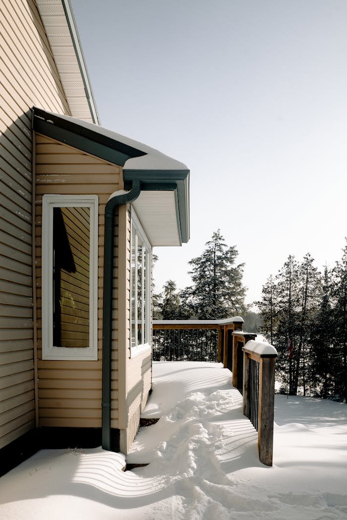 Services A serene winter scene capturing a modern house exterior with fresh snow on the deck.
